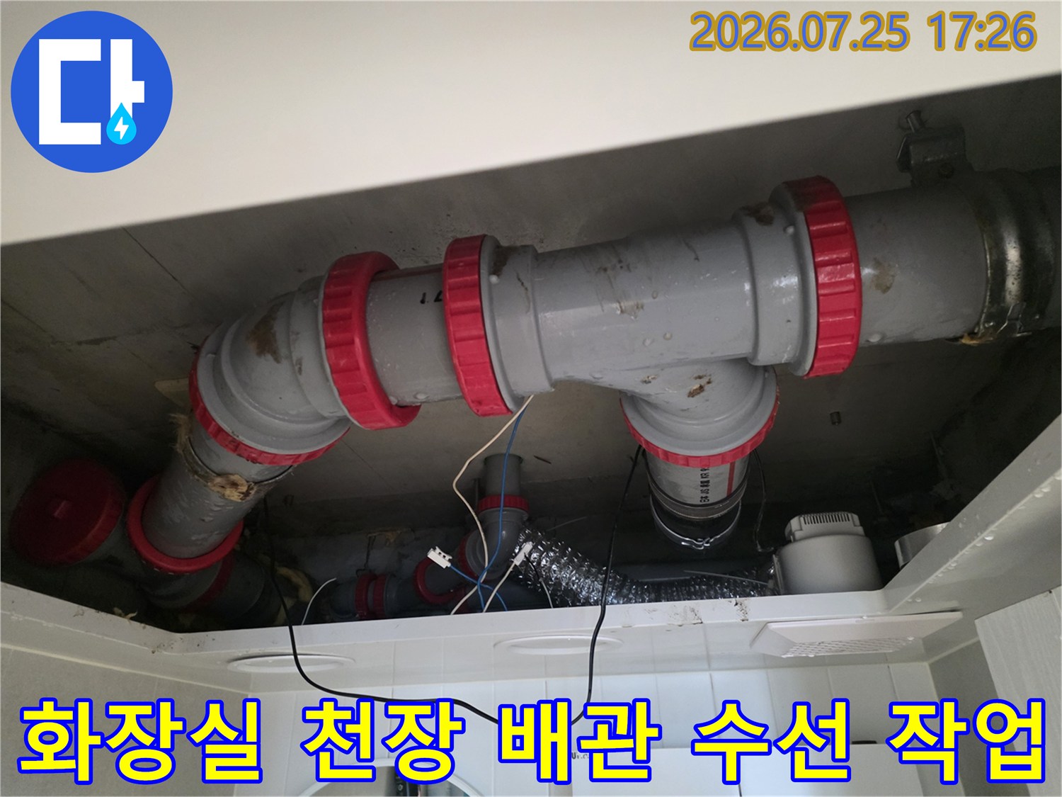 빨간색 조임띠로 고정된 회색 배관의 누수 보수 현장