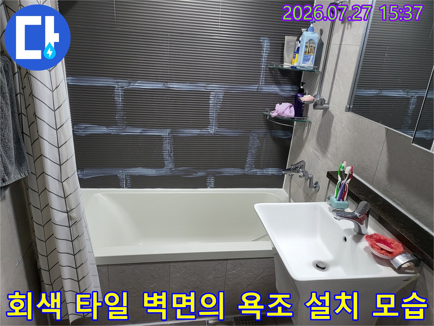 가로 줄무늬 회색 타일이 시공된 화장실-흰색 욕조와 세면대가 연결된 구조