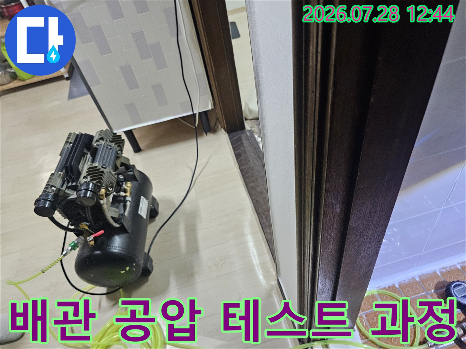 창틀 하부 배관 연결부에 장비를 설치하여 누수 여부를 확인하는 현장 사진