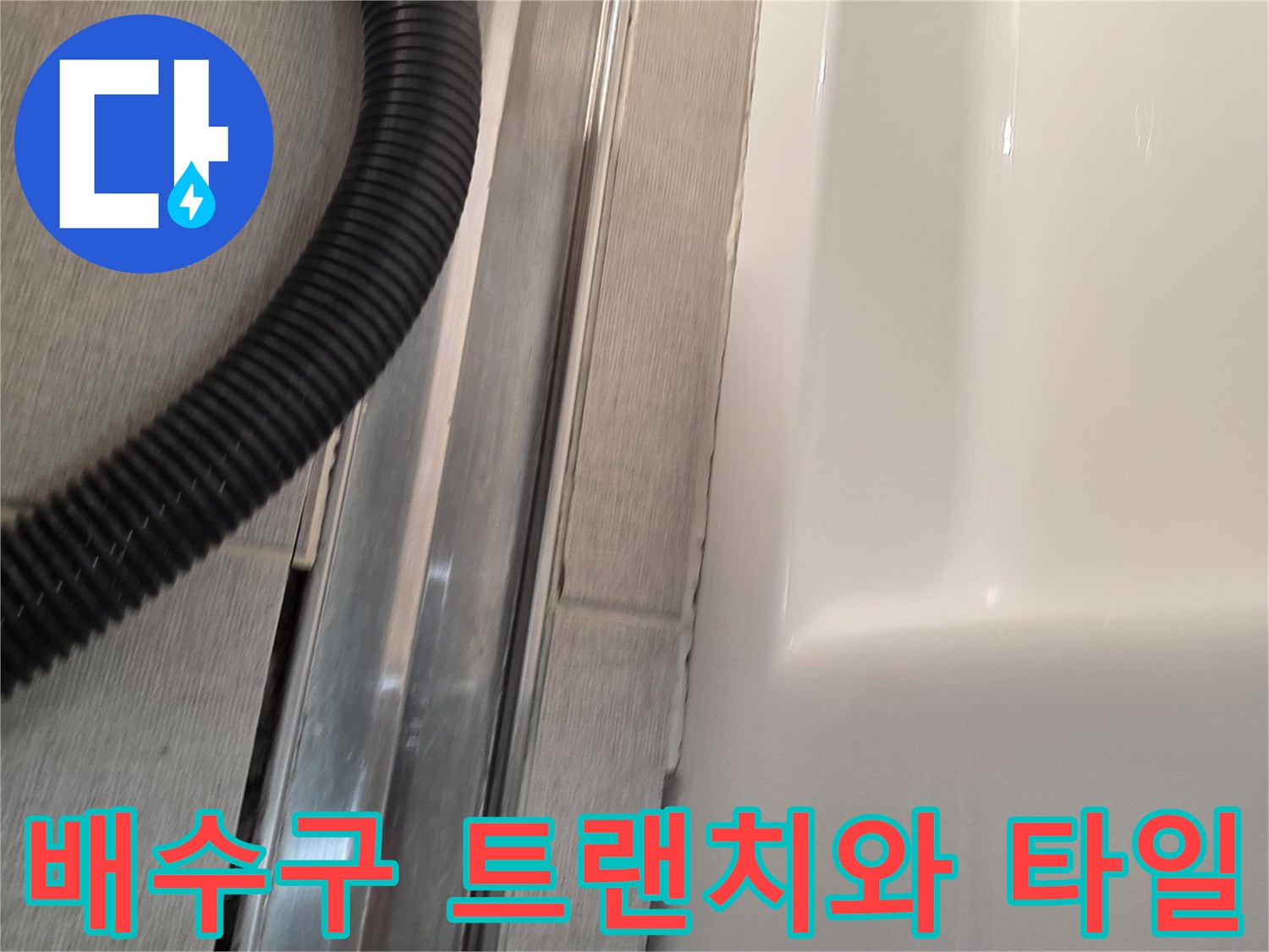 금속 배수구 프레임과 욕실 타일이 맞닿은 지점의 상태를 찍은 사진입니다.