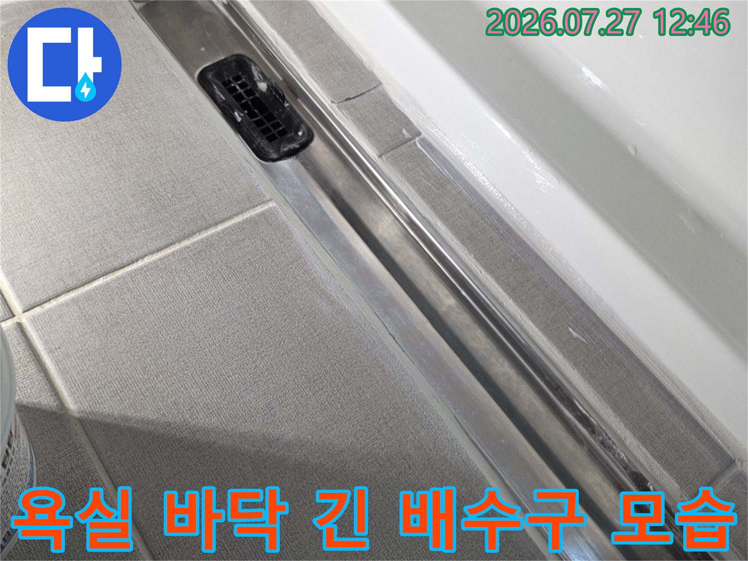 흰색 욕조 옆으로 설치된 금속 소재의 트랜치형 배수구-사진