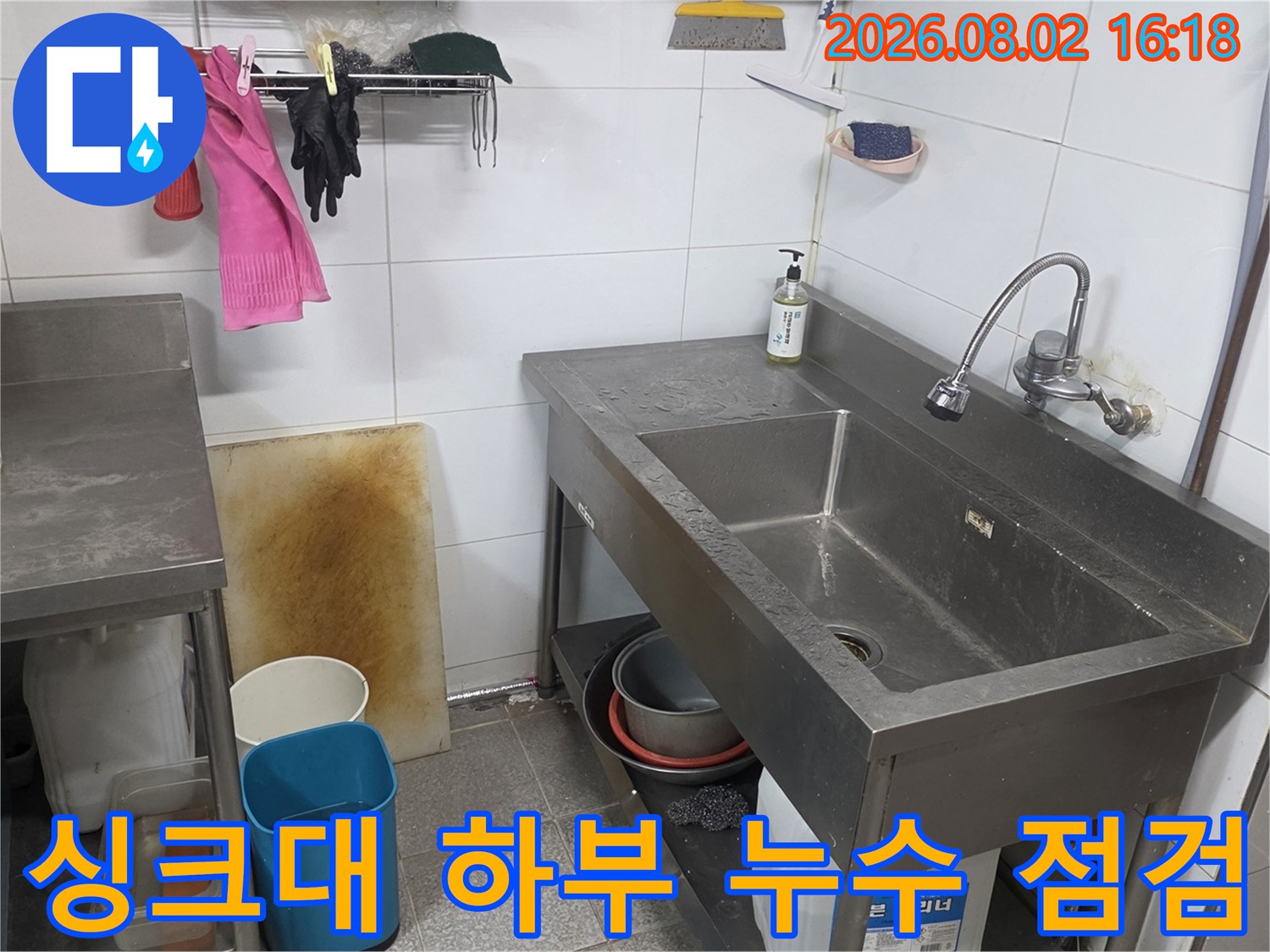 스테인리스 싱크대 구조물과 연결된 복잡한 배관들