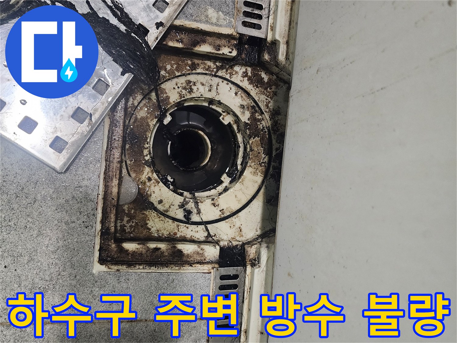 배수구 주변 타일 틈새로 오염된 물이 스며든 흔적을 보여줍니다.