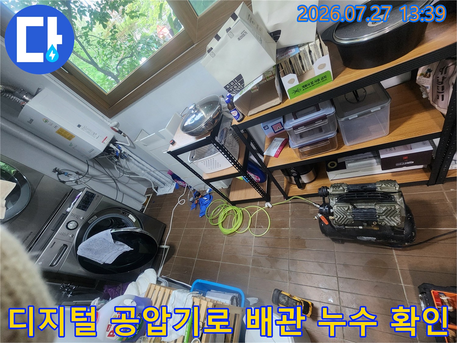 세탁기 옆 보일러실 바닥에서 진행 중인 배관 공압 테스트-노란색 연결 호스와 측정 장비