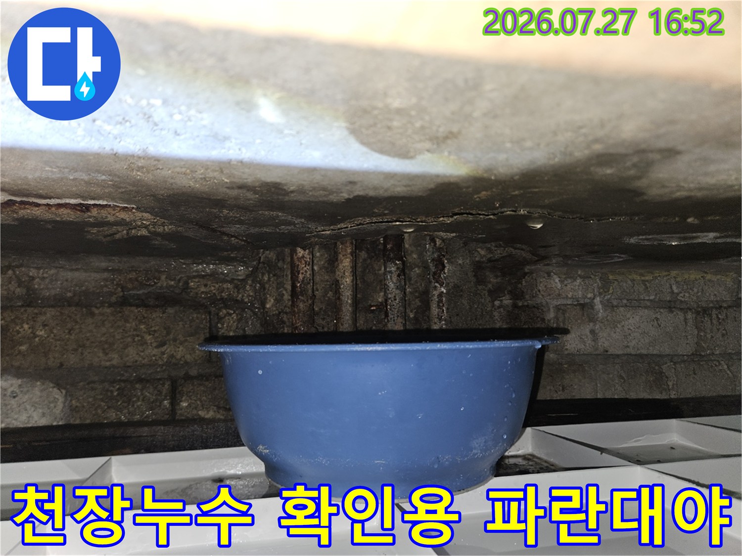 화장실 천장에서 떨어지는 물을 받기 위해 배치한-파란색 플라스틱 대야 사진