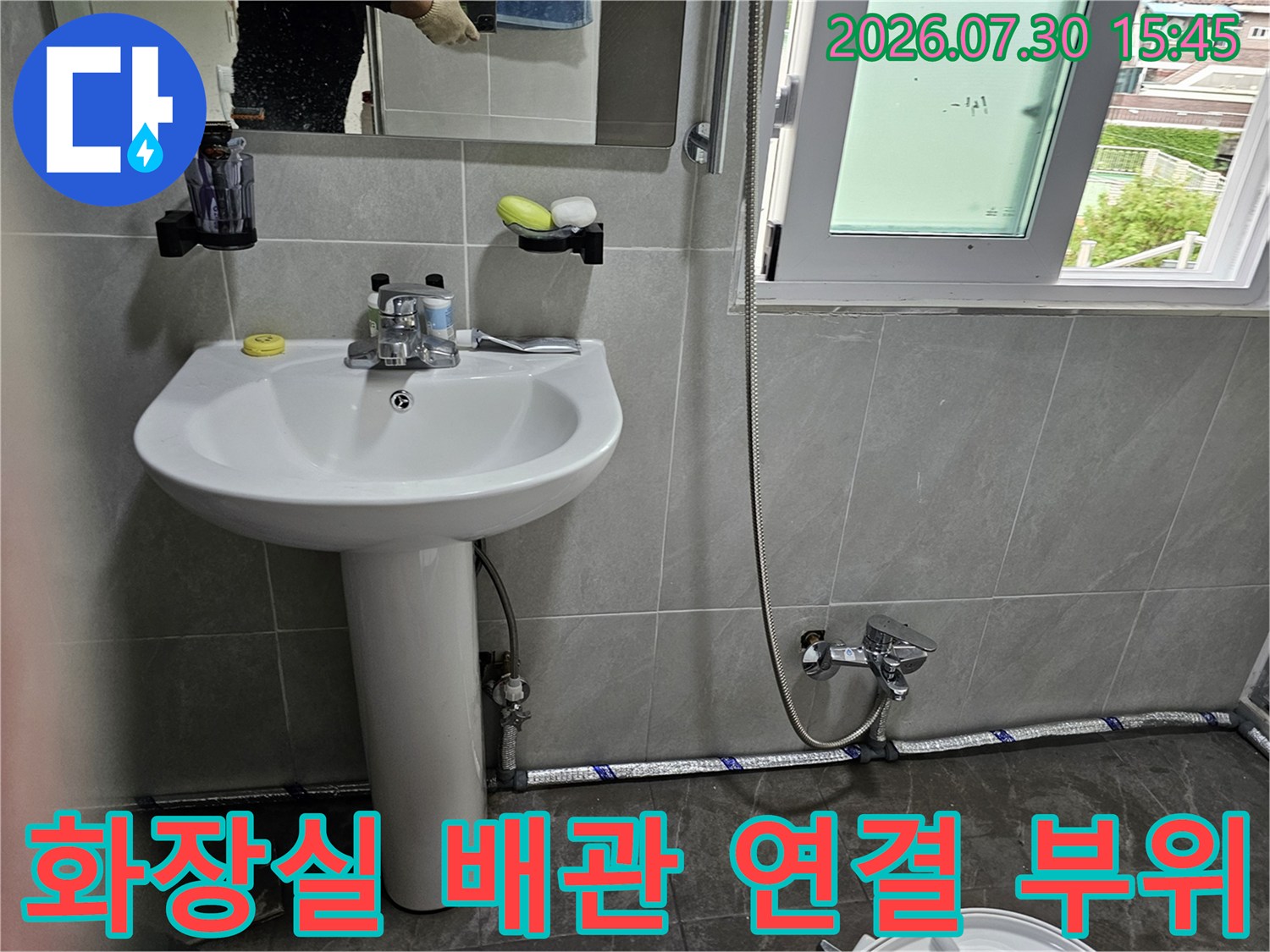 화장실 내 수직 배관과 변기 하단 밸브 조절 장치의 정밀 점검 상황