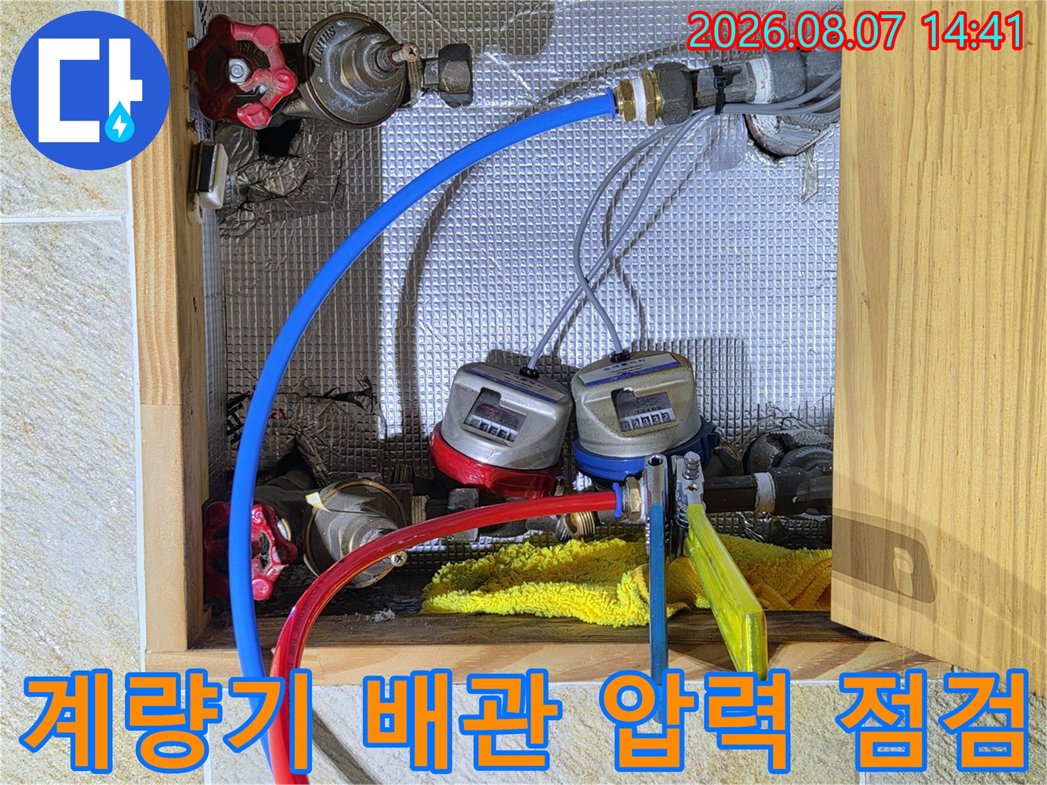 수원 영통구 현장의 수도 계량기와 연결된 파란색 및 빨간색 압력 테스트 호스 모습입니다.