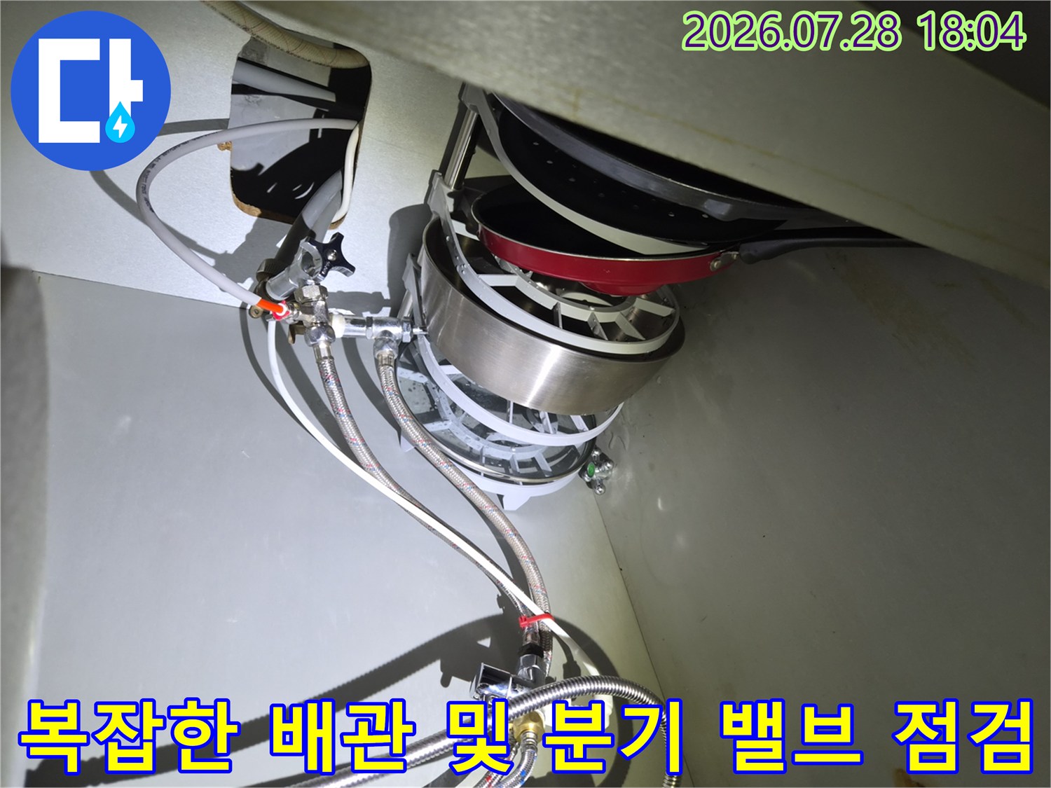 식기세척기와 연결된 금속 재질의 배관 부품과 수전용 호스 배열