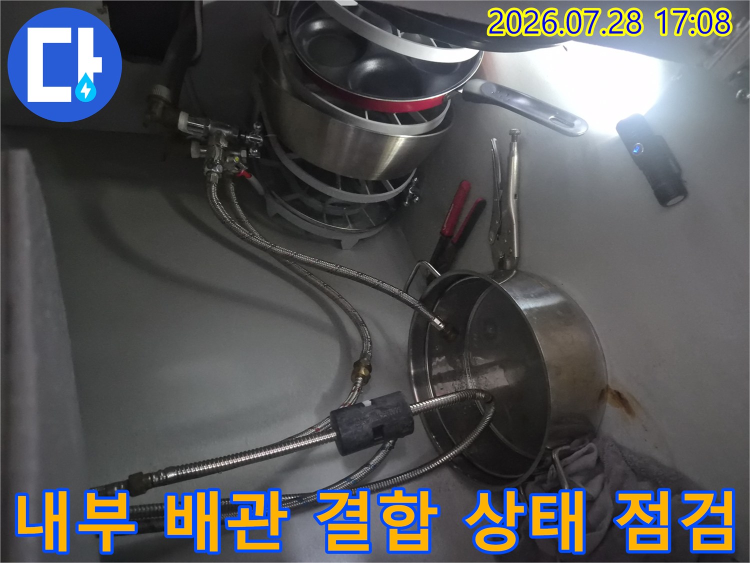 식기세척기용 배관과 싱크대 수전 사이의 연결 부위를 정밀하게 확인하는 모습