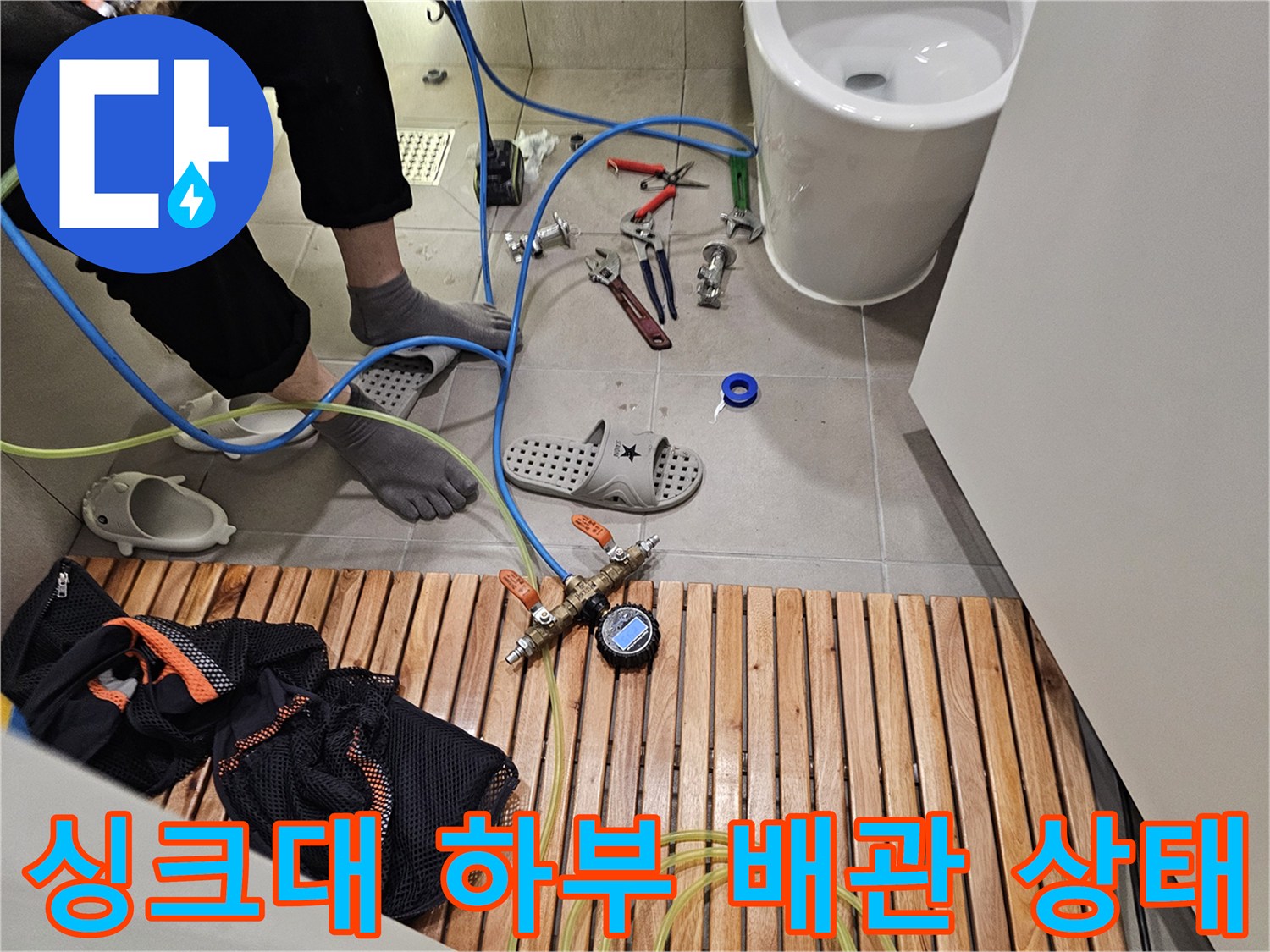 작업자가 확인 중인 싱크대 아래쪽 배관 연결 부위