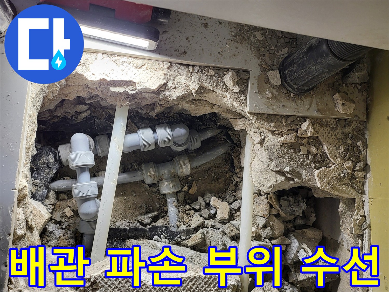 바닥을 파낸 자리-새로 설치된 흰색 온수 배관과 연결 소켓