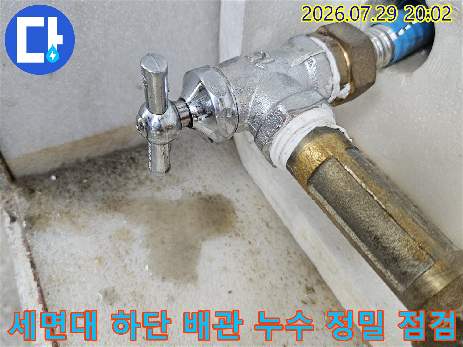 세면대 밑에 설치된 금속 소재 밸브와 노출형 파이프 연결 부위