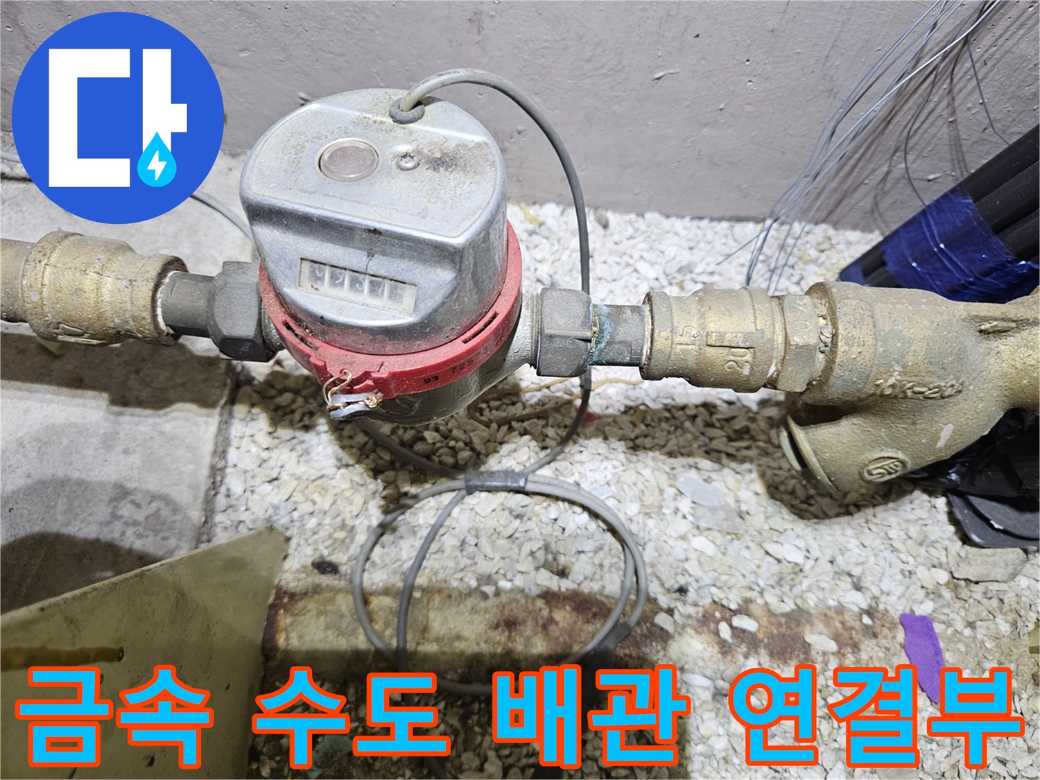 수도 계량기와 은색 금속 밸브가 연결된 부분의 상세 사진
