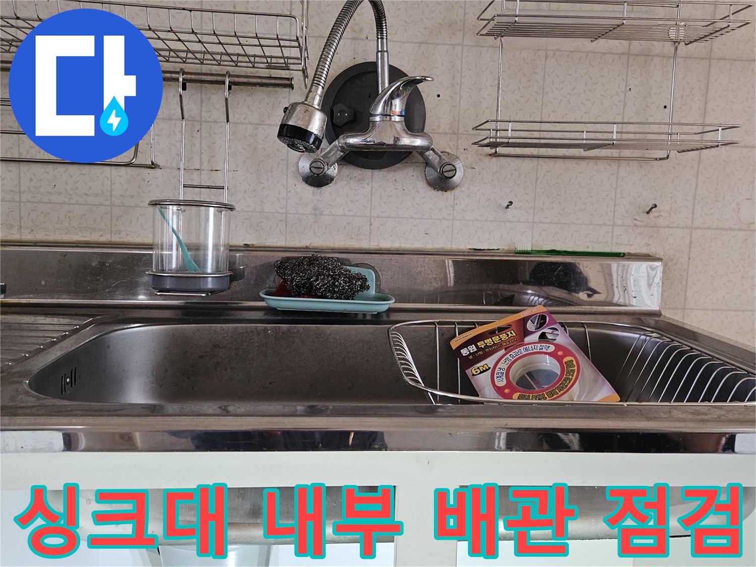 주방 싱크대 하단 수전 연결 부위와 호스의 상태를 보여줍니다.
