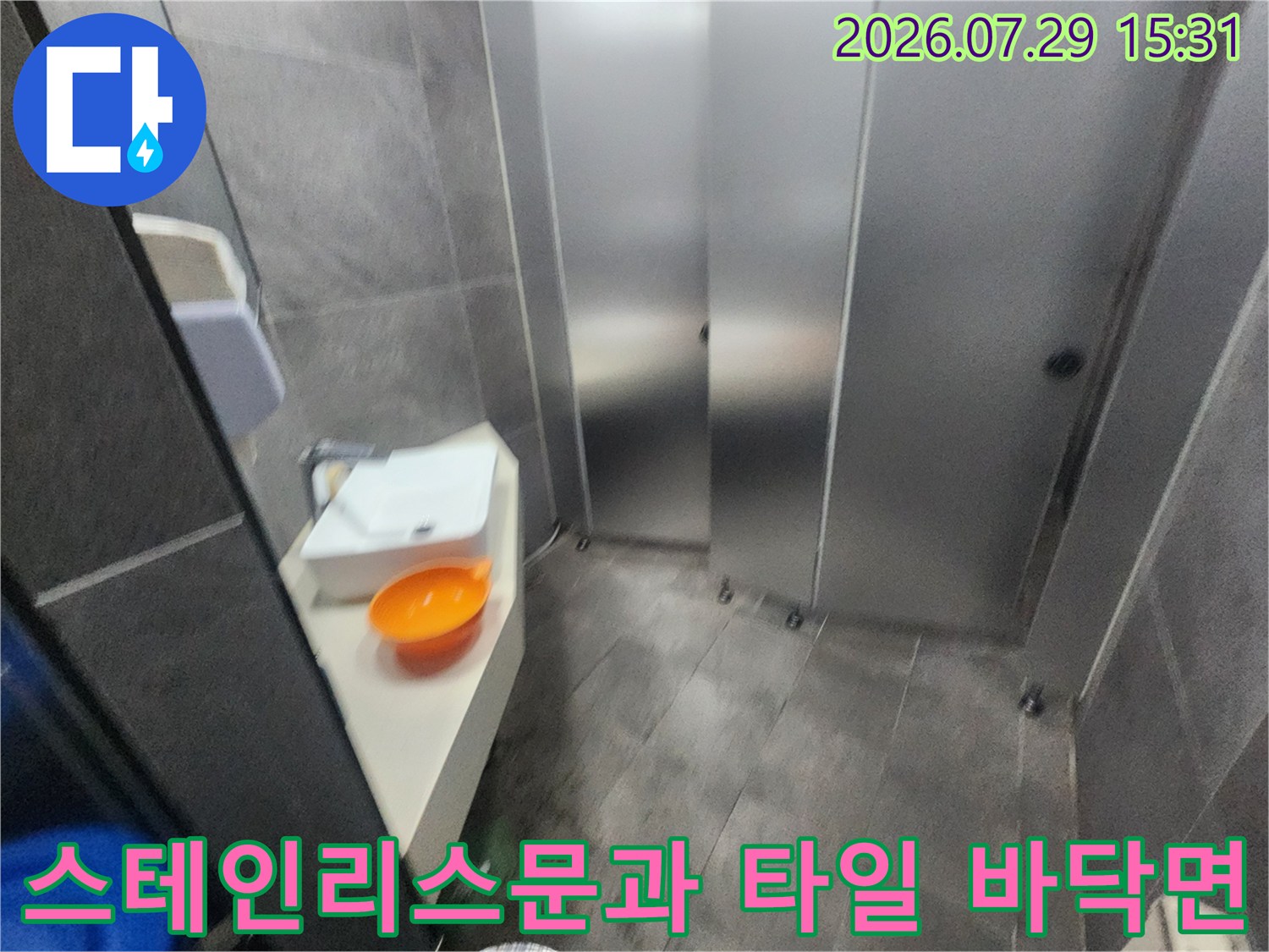 화장실 내 배관 연결부와 마감재 상태를 정밀하게 조사하는 전문 엔지니어의 현장 사진