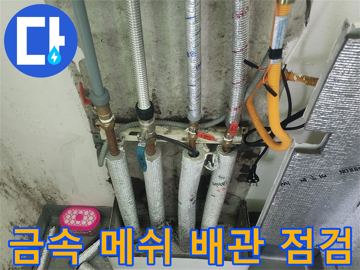 보일러실 내부의 금속 재질 배관과 노란색 호스 연결부
