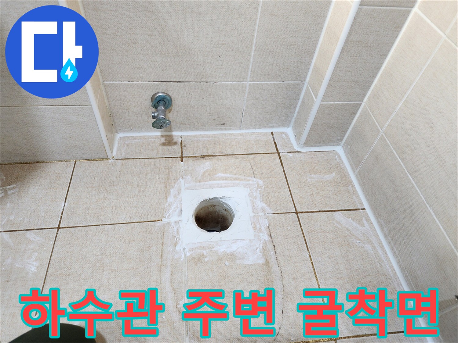 배수구 배관 주위의 타일이 제거된 상태를 보여줍니다.