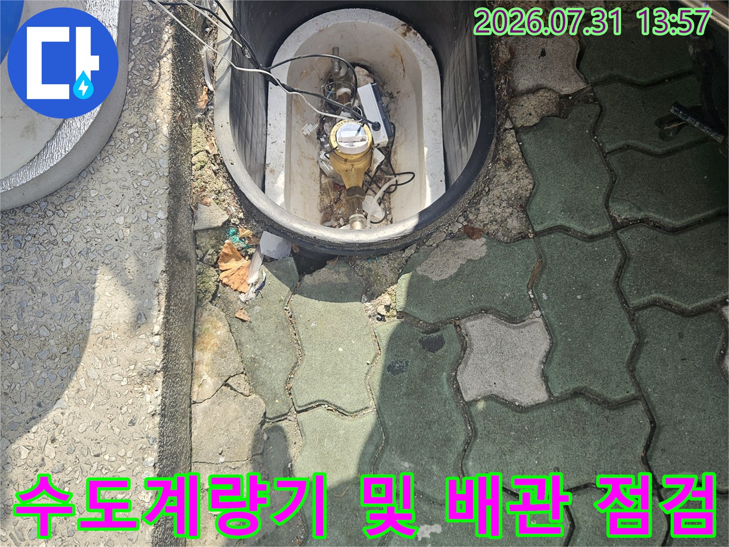 먼지 쌓인 배관과 계량기가 설치된 맨홀 내부 점검 모습