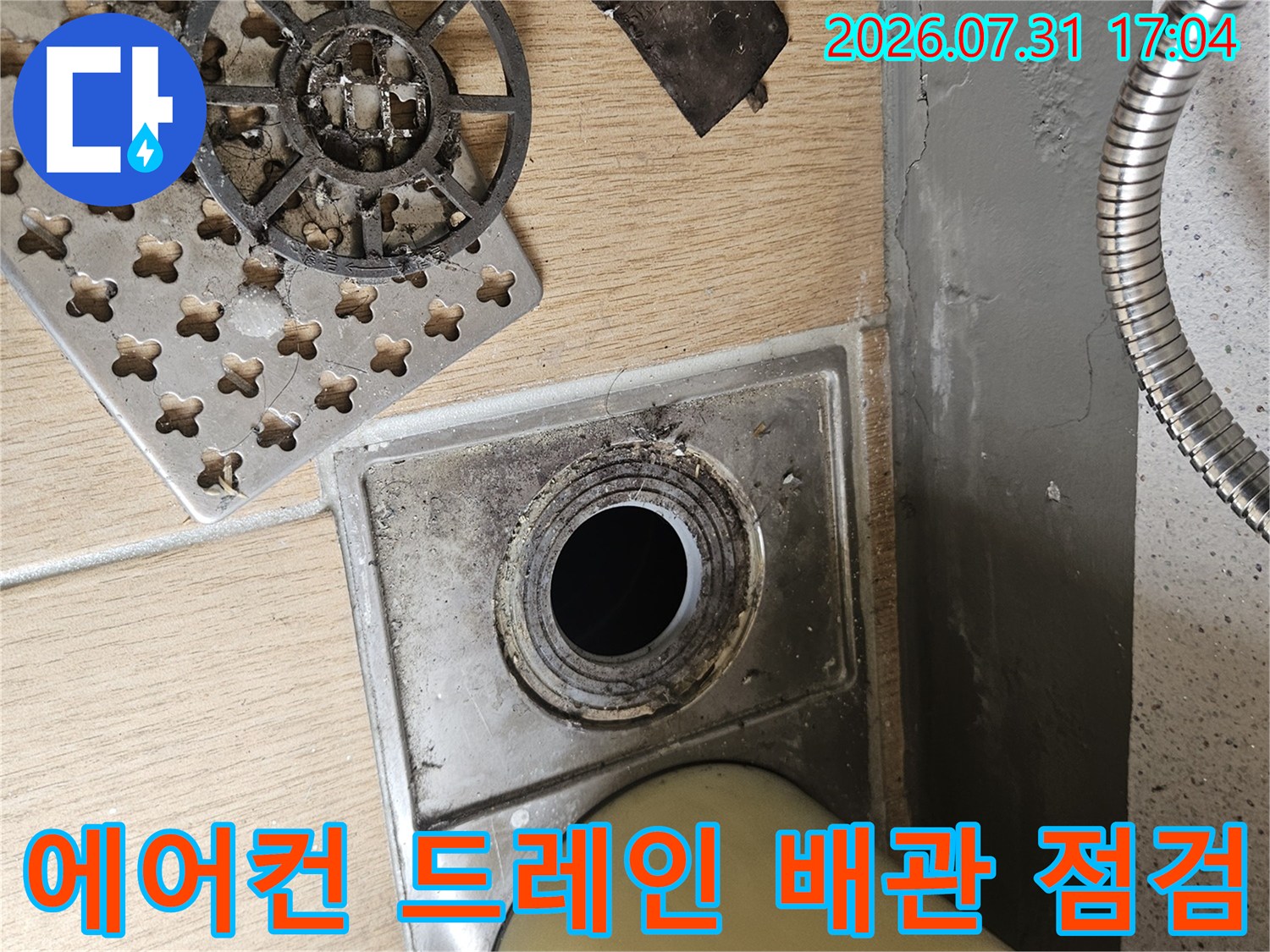 배출구가 노출된 에어컨 드레인 배관과 주변 배수 시설을 점검하는 모습