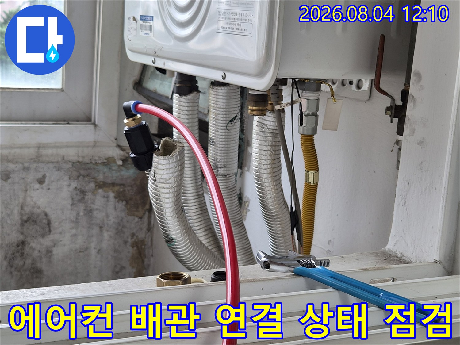 에어컨 실외기 연결 부위의 단열재를 제거하고 배관 체결 상태를 확인하는 모습