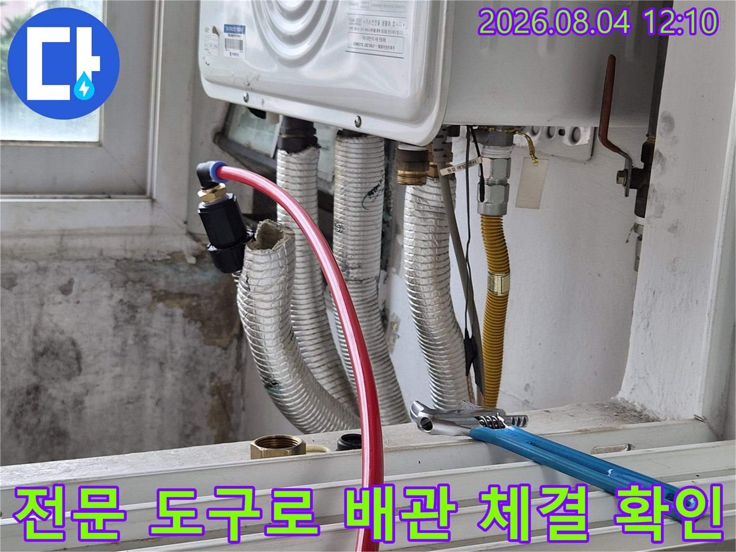 파란색 렌치를 사용하여 에어컨 관련 배관들의 연결 부위를 세심하게 살피는 모습