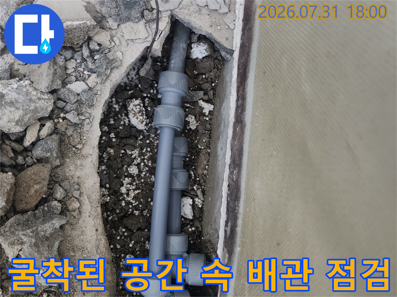 지면 아래 숨어있던 회색 배관과 엘보 부속들의 노출 상태를 촬영한 사진