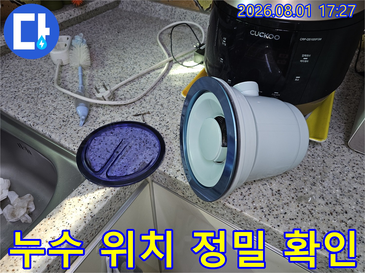 싱크대 아래 공간에서 분리된 배관 부품과 도구들