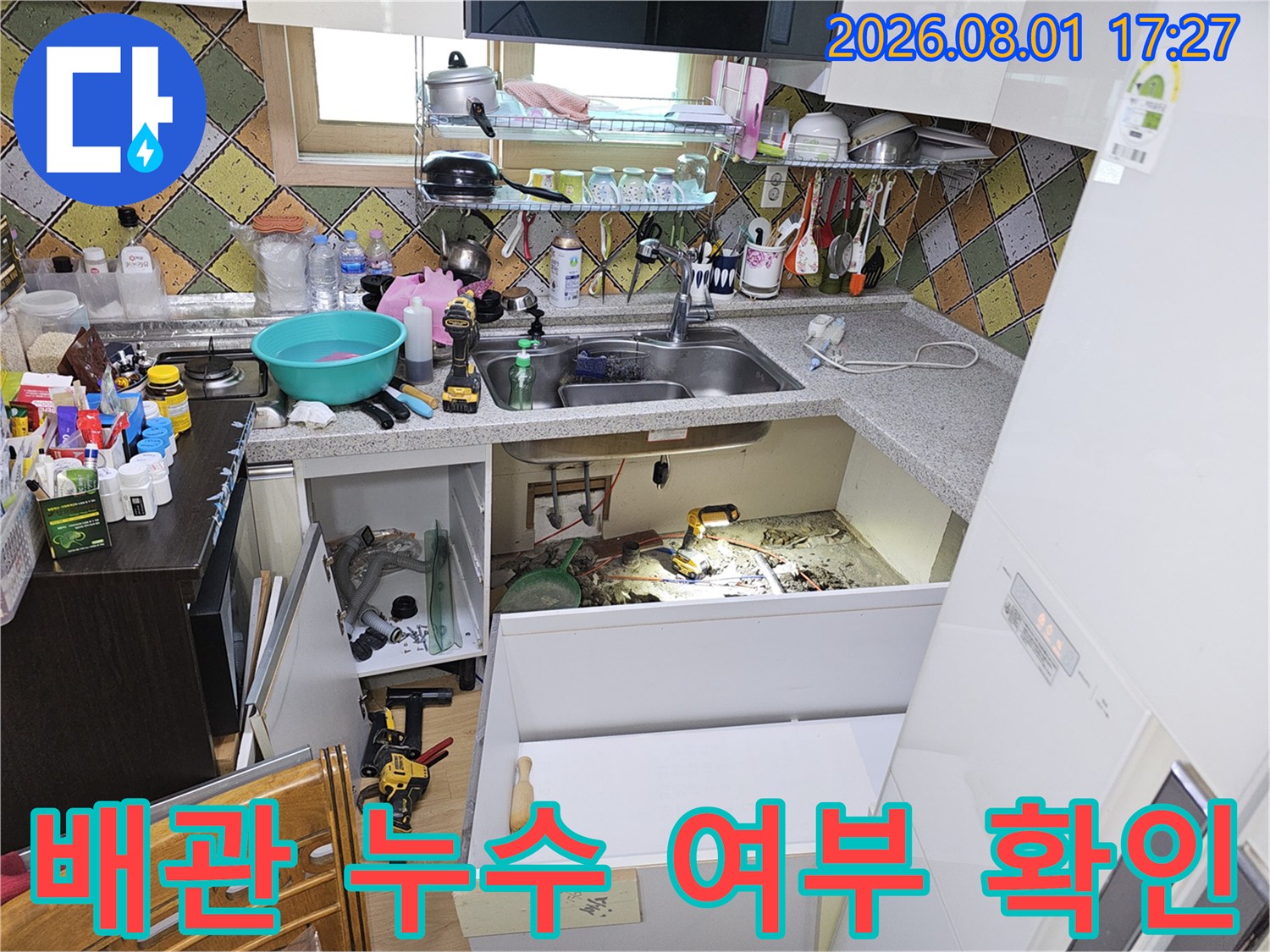 싱크대 하단 배관 구조를 파악하고 노출된 부위를 점검하는 모습