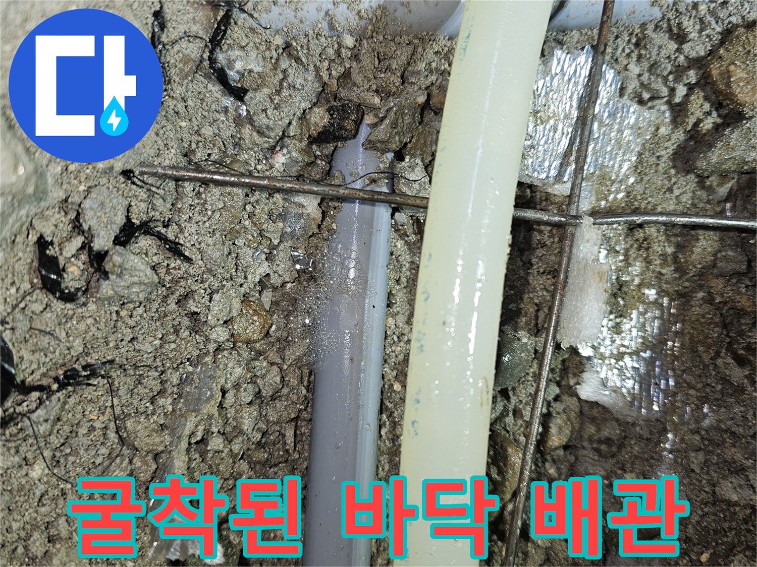 싱크대 하부 굴착-문제가 된 회색 배관과 주변 흙의 상태를 보여주는 사진입니다.