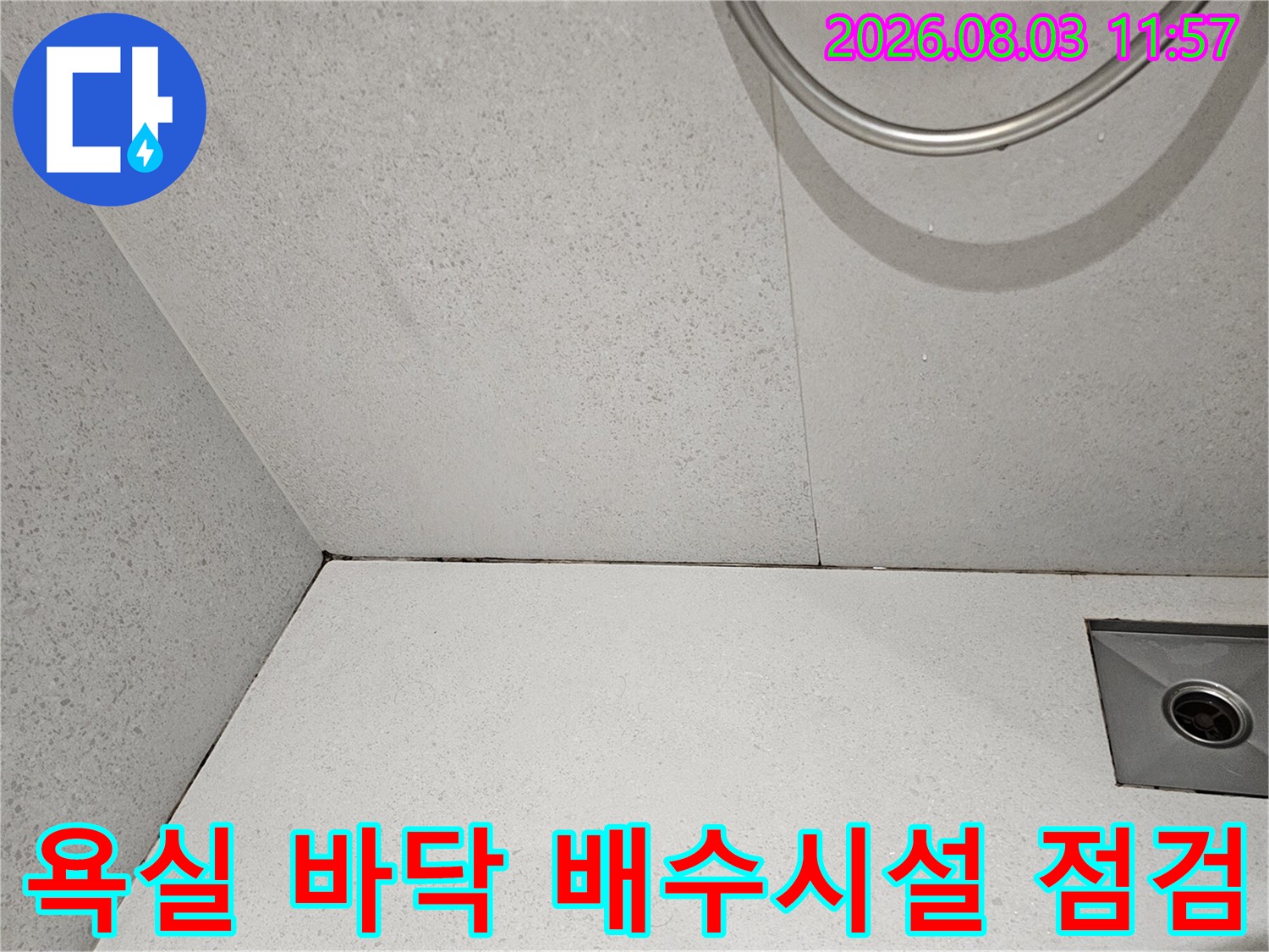 회색 타일과 금속 소재의 배수 트렌치 구조물 확인