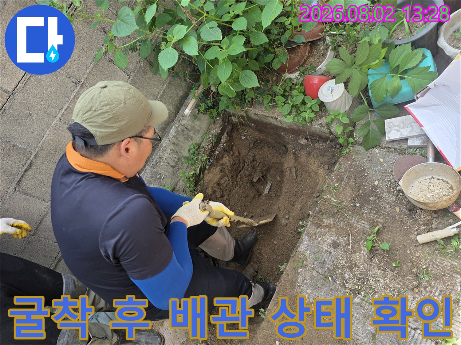작업자가 흙 속에서 파손된 배관을 찾아내어 세부 점검하는 모습