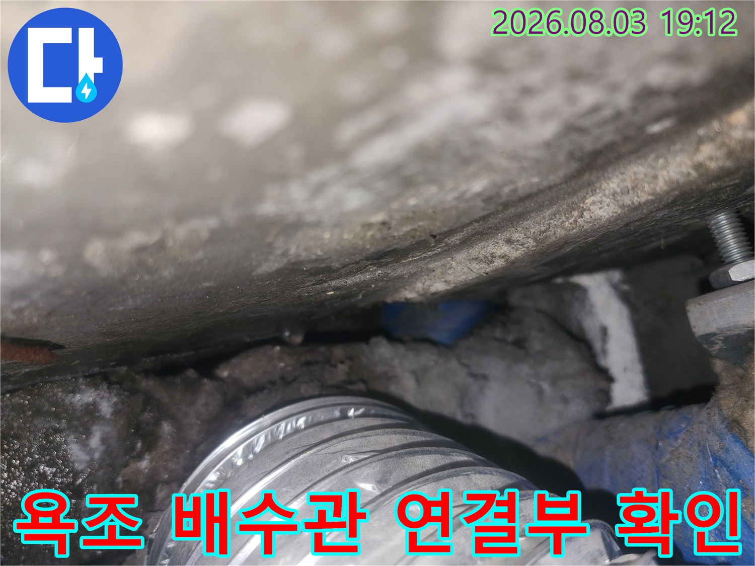 욕조 밑에 위치한 회색 플렉시블 호스(배수관)의 구조를 상세히 촬영한 사진