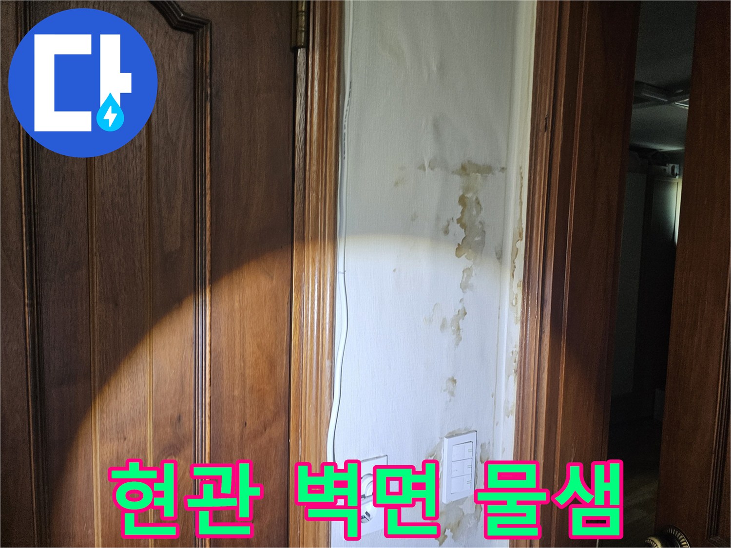 누수로 인해 젖고 얼룩진 현관 입구의 벽지 모습