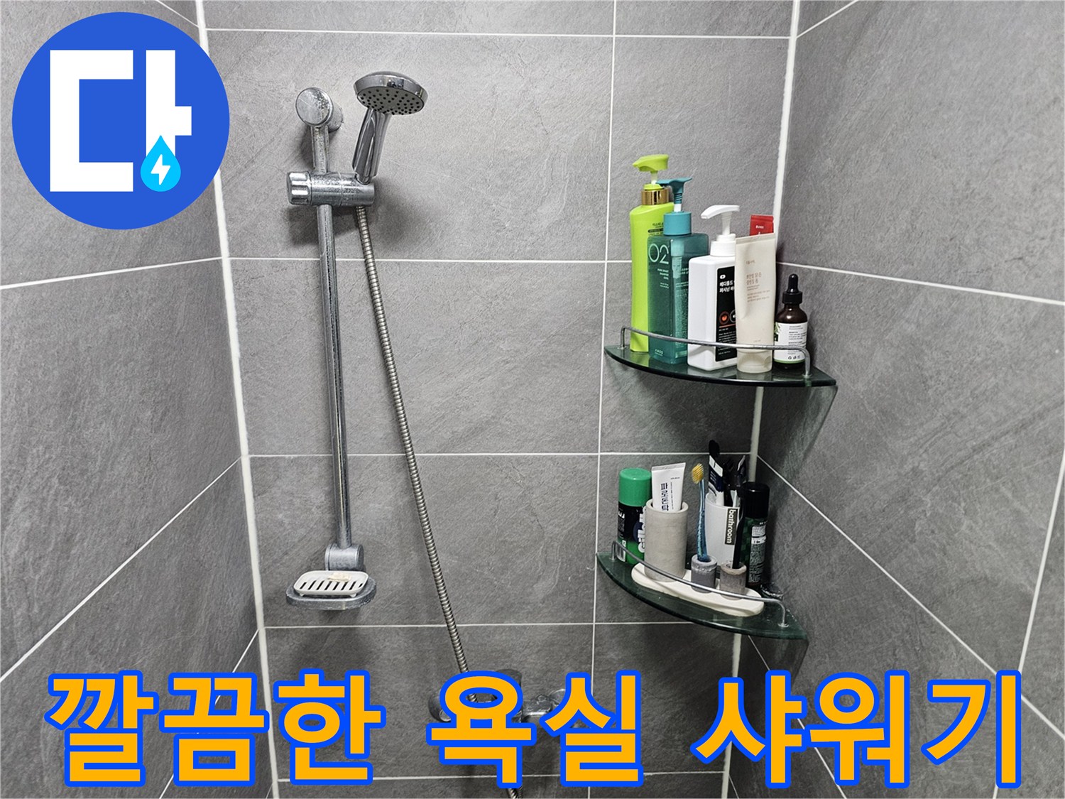그레이 타일 벽면에 설치된 샤워기 헤드와 수전 모습