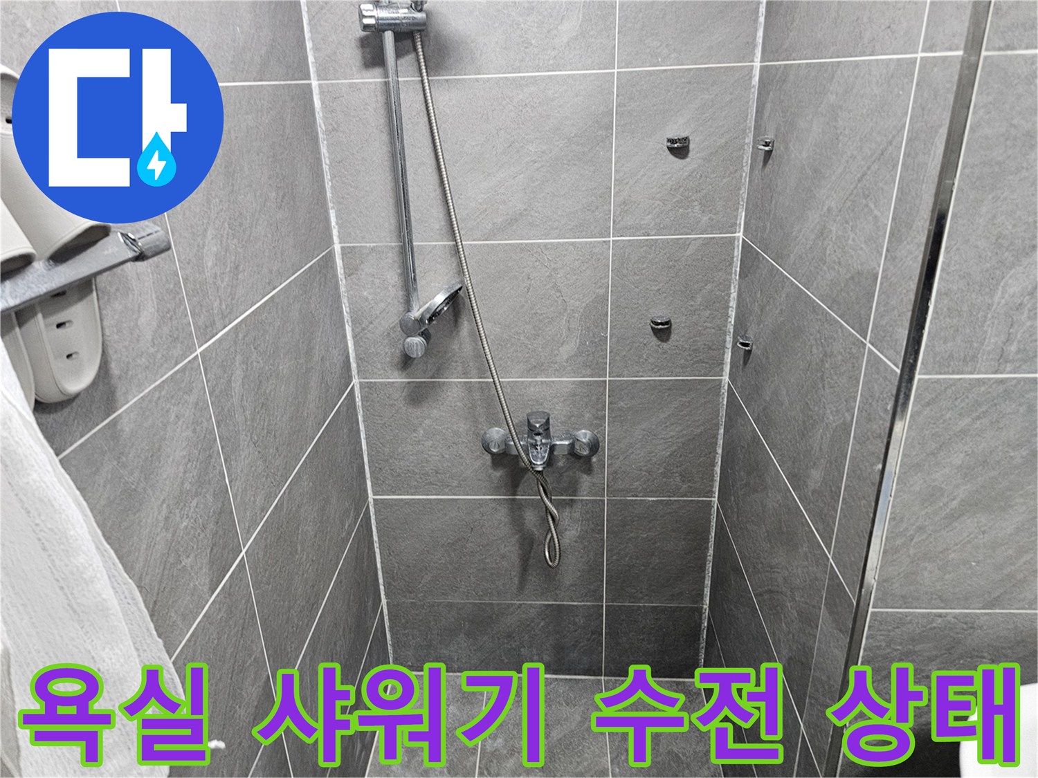 그레이톤 타일 벽면에 설치된 샤워기 수전과 수압 조절 밸브 모습