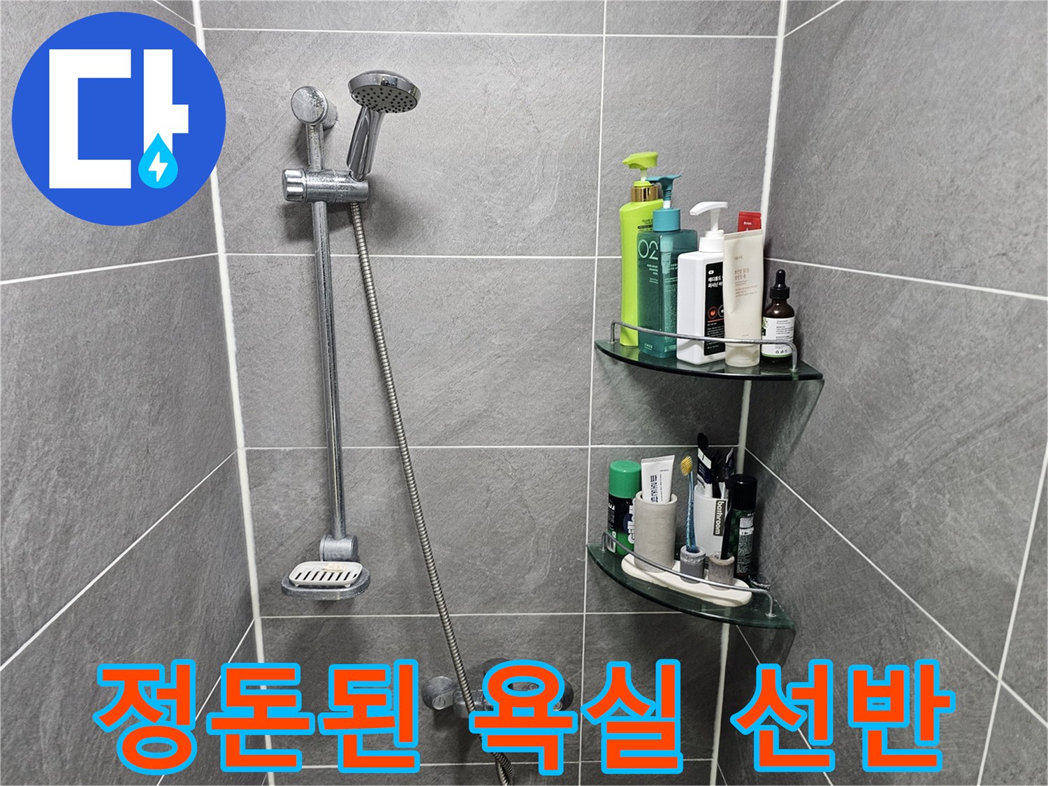 샤워 용품이 놓인 투명 욕실 선반과 샤워기 수전