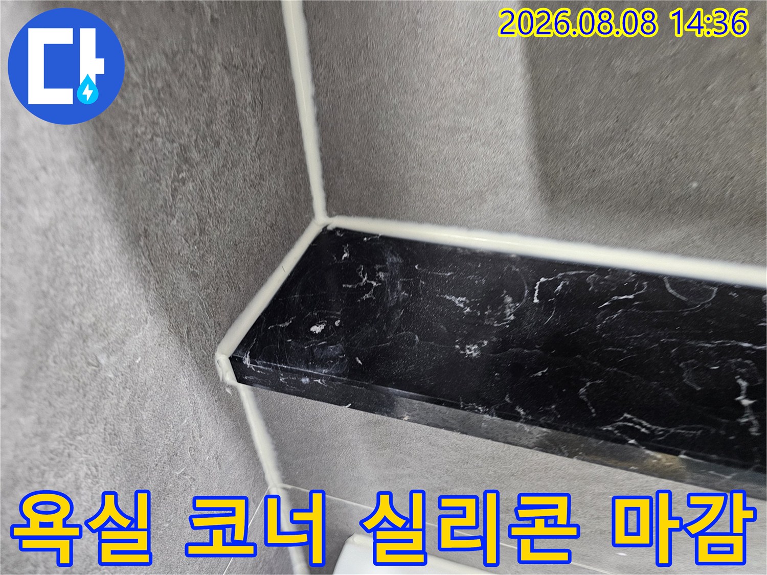 어두운색 대리석 선반과 회색 타일의 접합부-실리콘 마감 처리