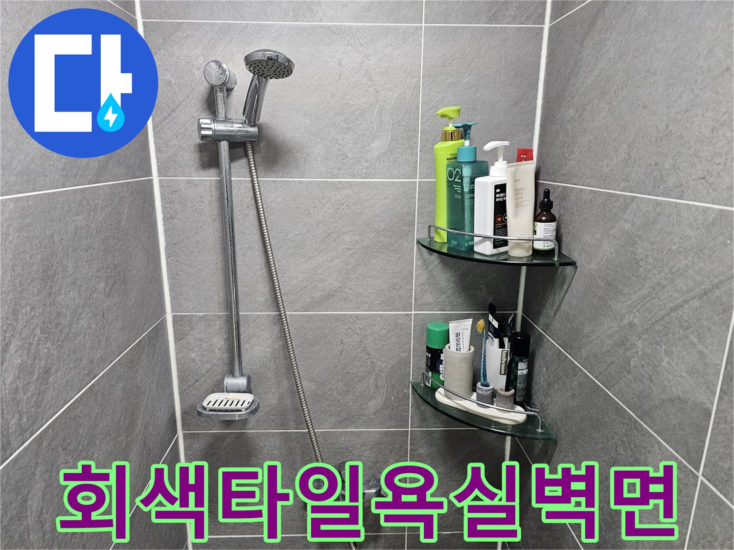 회색 타일로 마감된 욕실 벽면과 샤워기 수전 모습