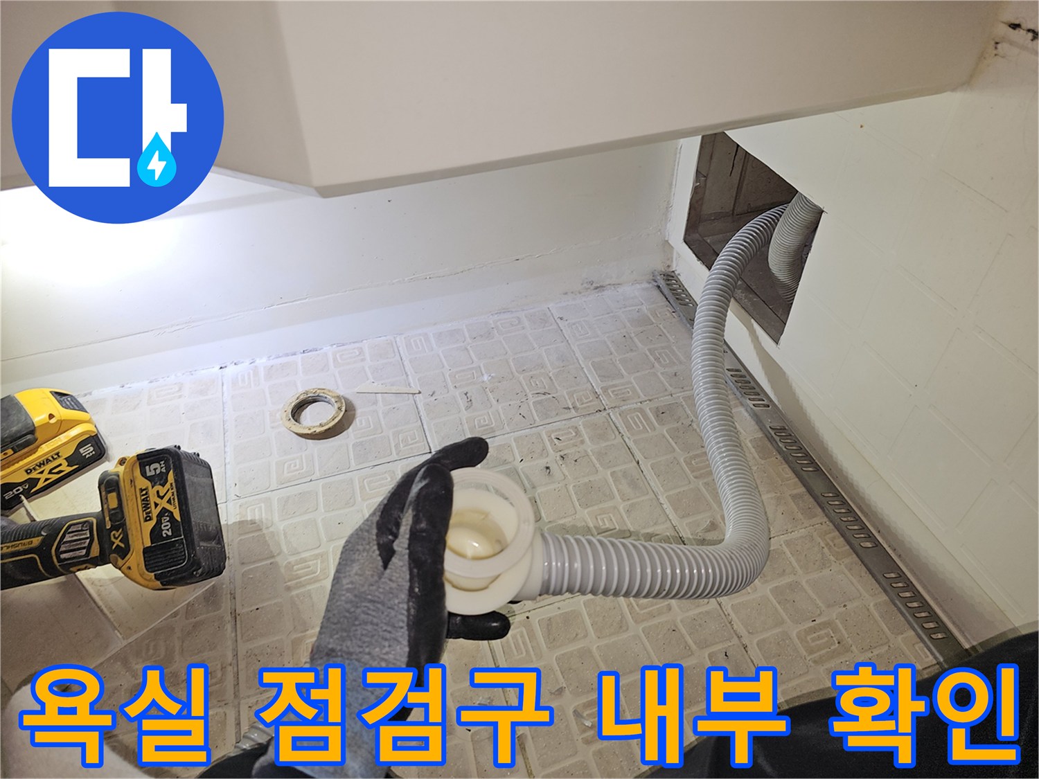 타공된 공간을 통해 노후된 배수 호스를 점검하는 엔지니어의 손길