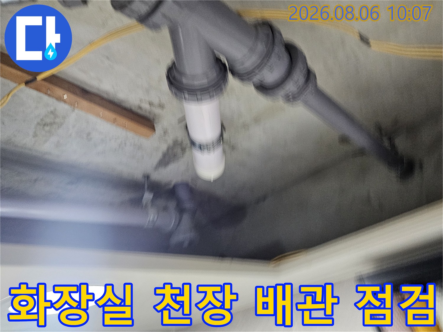 천장 내부에 노출된 배관 연결부와 슬라브 경계면을 점검하는 모습
