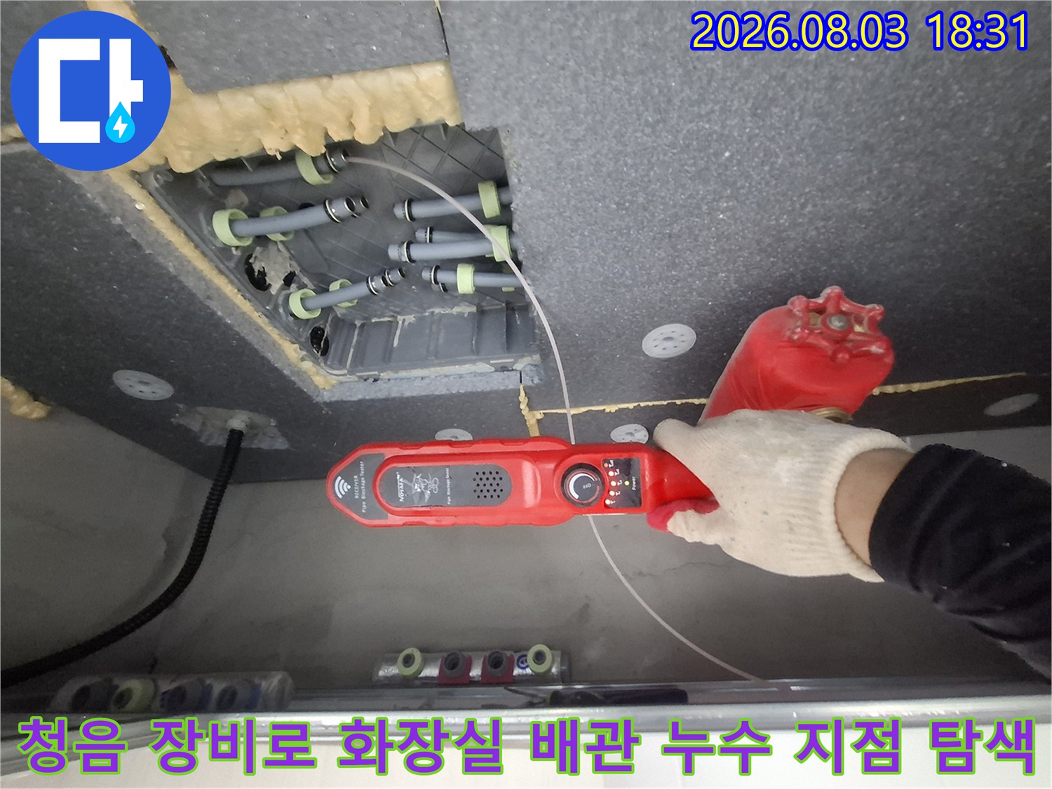 화장실 천장 내부에 노출된 여러 개의 배관 중 누수가 발생하는 구간을 청음기로 정밀하게 찾는 과정