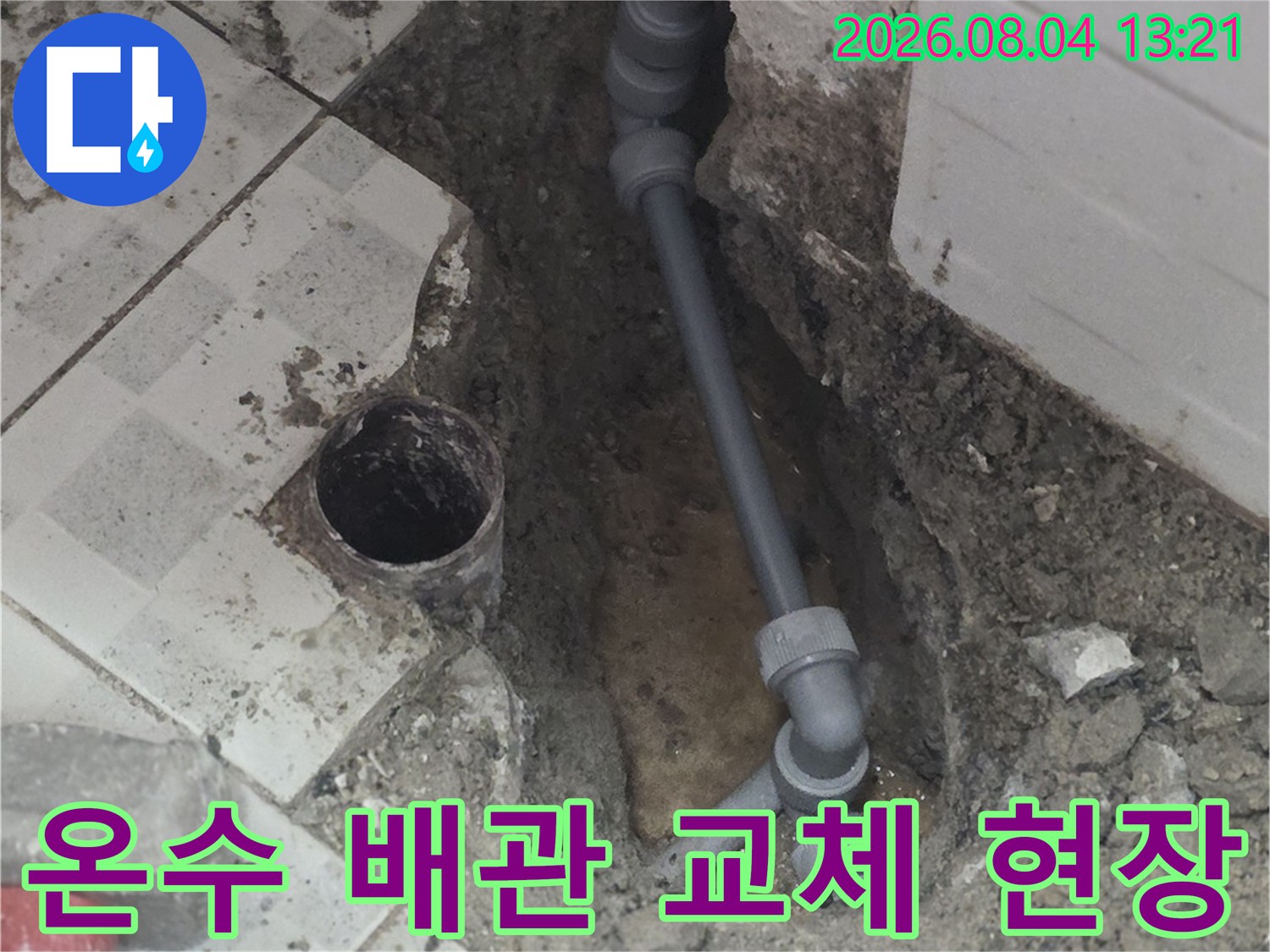노후된 온수 배관을 절단하고 새 연결 부품과 배관으로 대체하는 화장실 내부 수리 장면