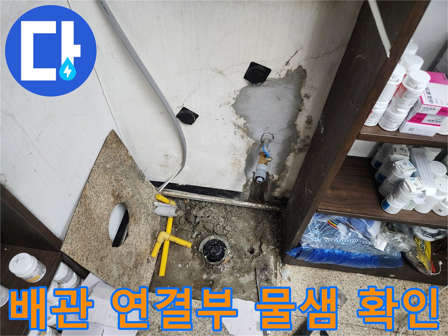 노후된 배관 연결 부위와 벽면의 젖은 흔적을 근접 촬영한 사진입니다.