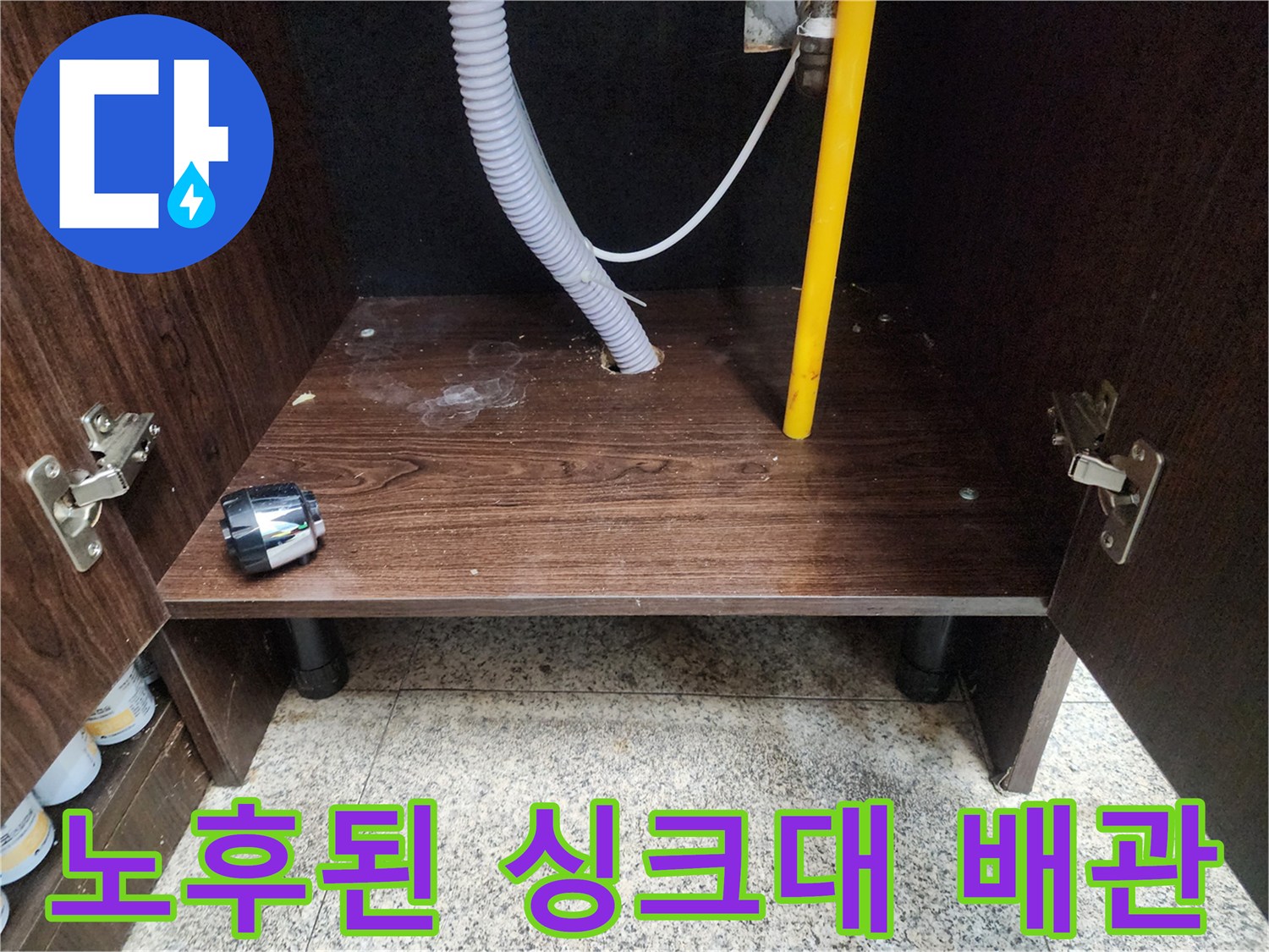 싱크대 하부장 내부의 주름 호스와 벽면 관통 배관 구조