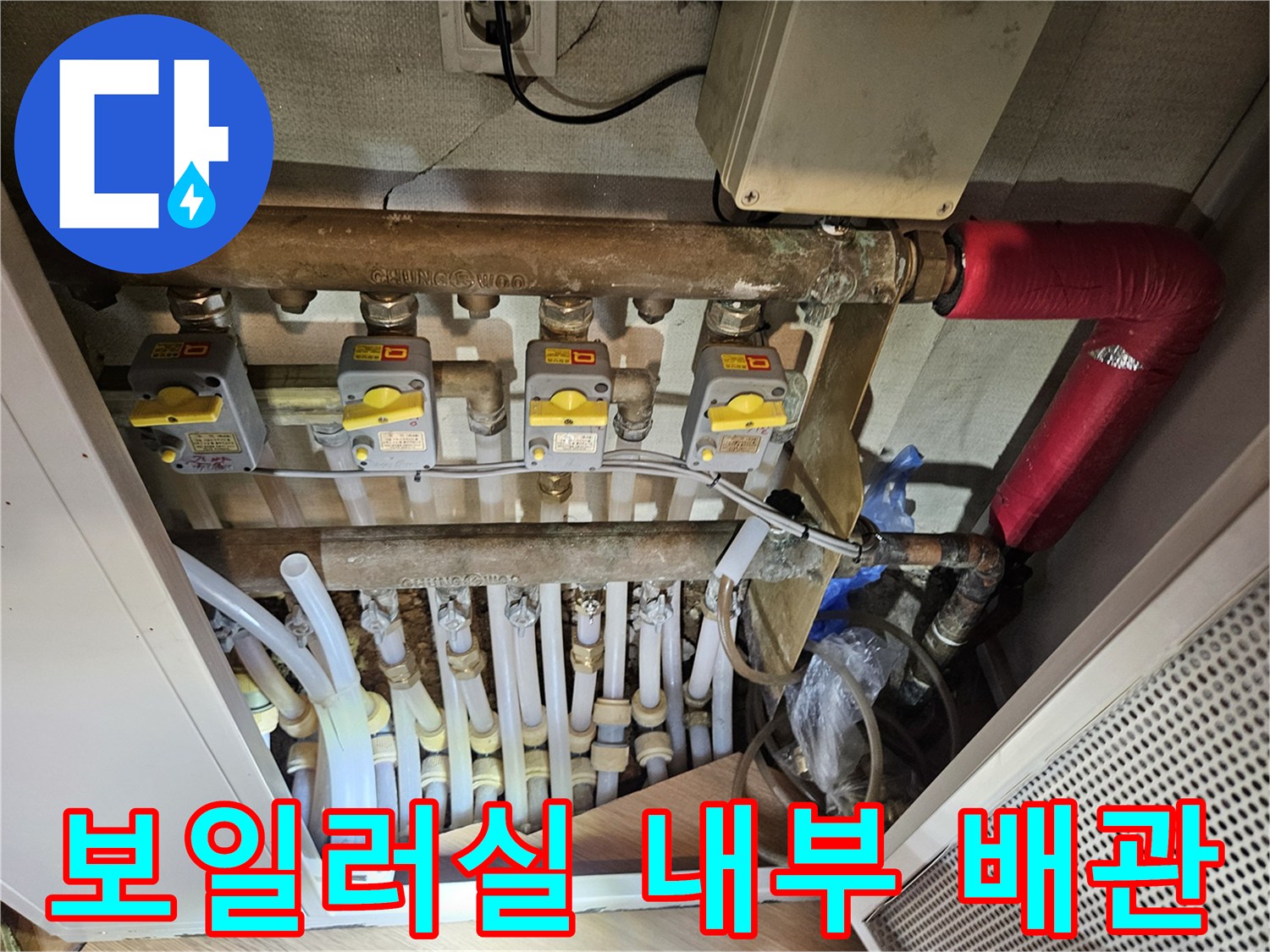 노란색 밸브가 설치된 난방 분배기와 연결된 여러 개의 배관들