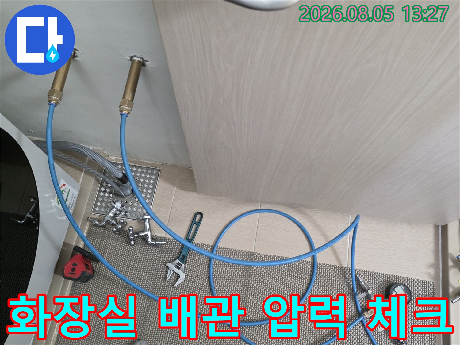 배관과 연결된 파란색 호스 및 공압 측정 장비의 모습