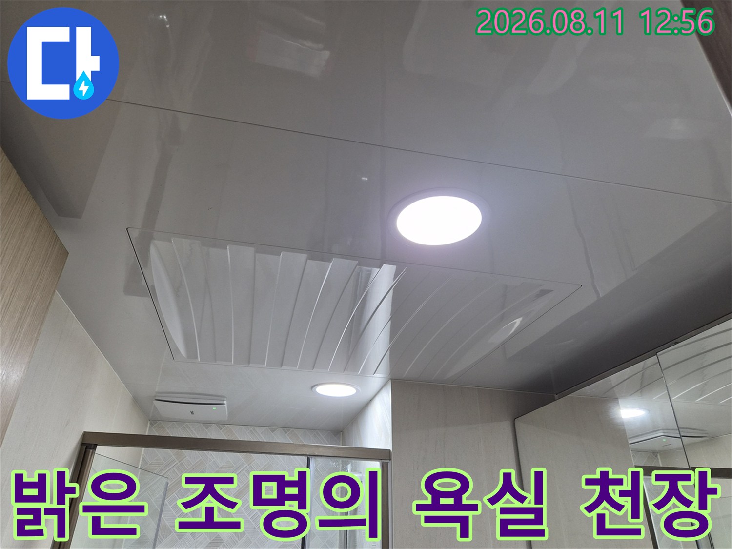 깨끗하게 마감된 화장실 천장 패널과 매립등 근접 촬영