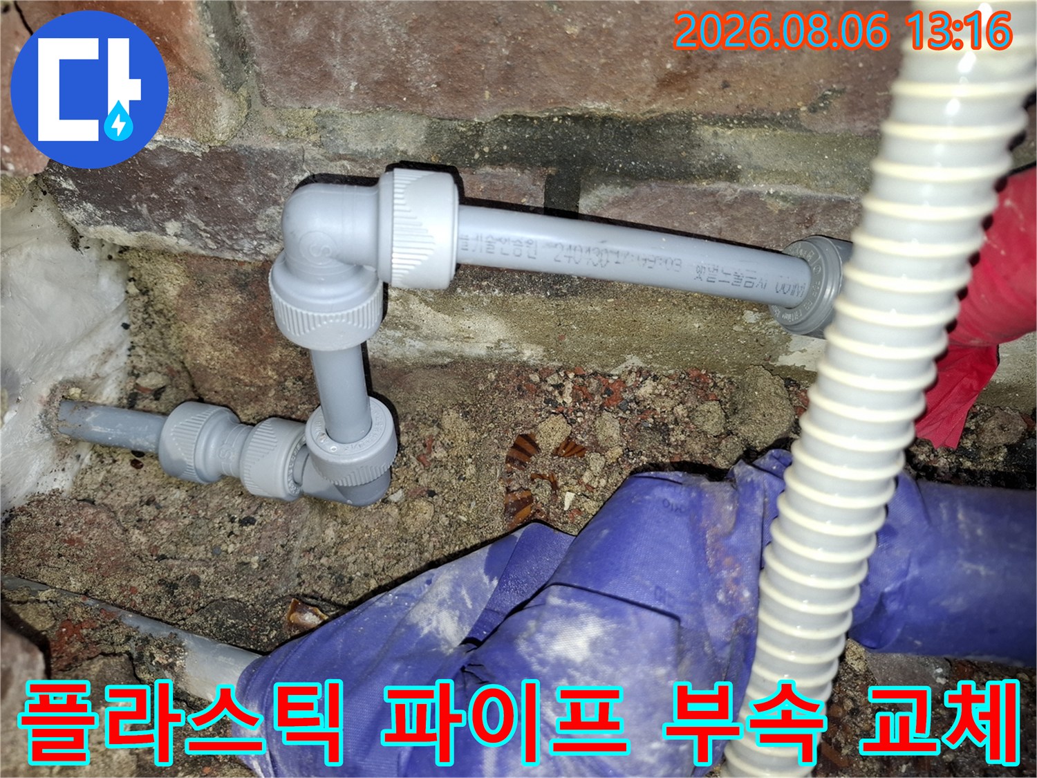 노후된 배관 연결 부위를 뜯어내고 새 부품으로 단단히 고정하는 공사 장면입니다.