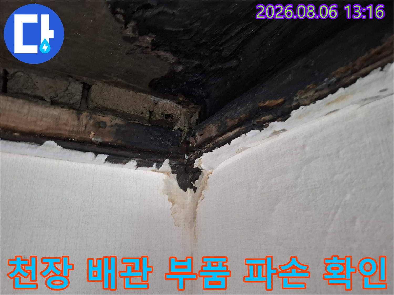 천장 안쪽의 젖은 배관 연결부를 상세하게 촬영한 사진