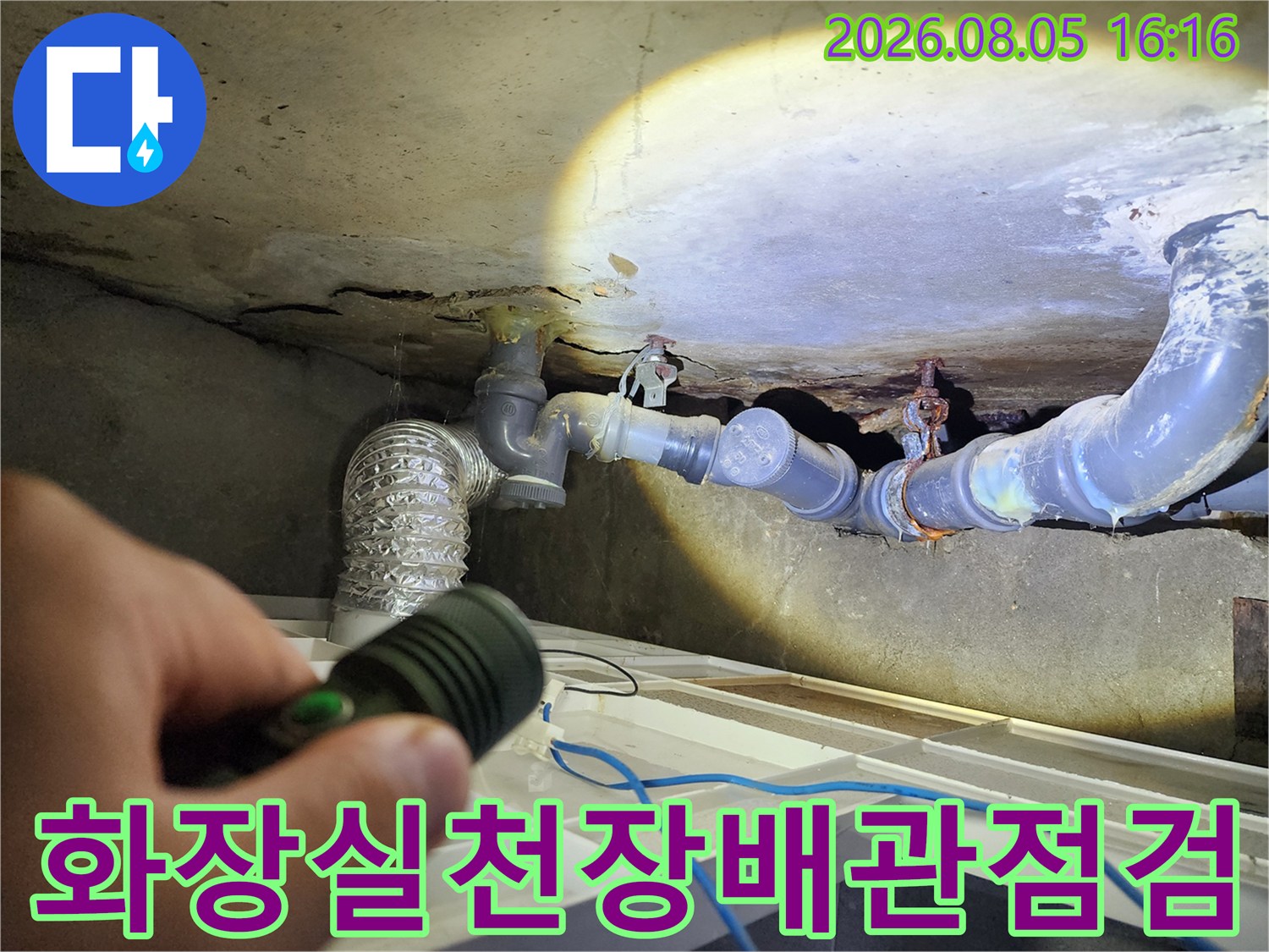 손전등으로 비춘 화장실 천장 배관 연결 부위 점검 모습